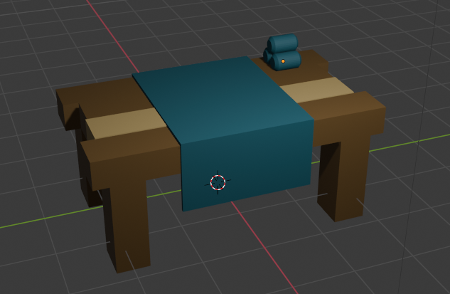 wooden table with cyan tablecloth and rolls of fabric